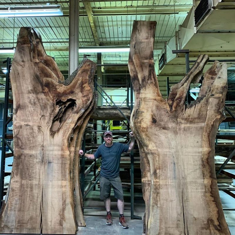 man between two large wood slabs